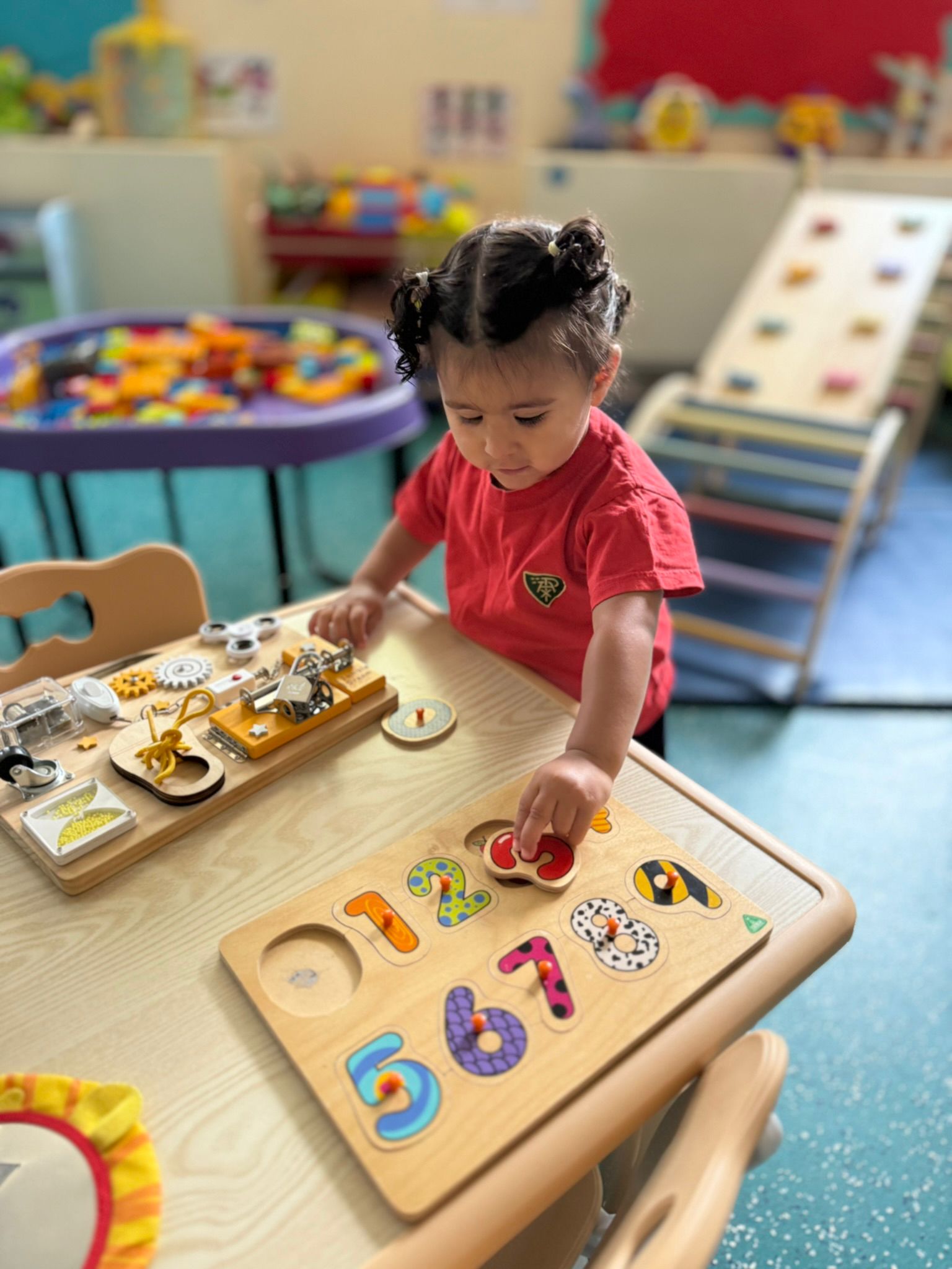 A child at Little Vita’s Nursery solving a wooden numbers puzzle